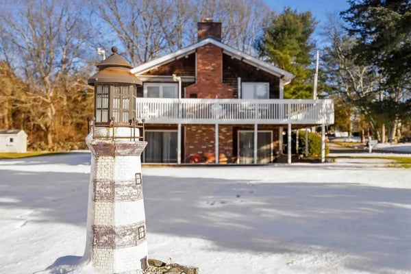 a house in the snow with a light post in front of it